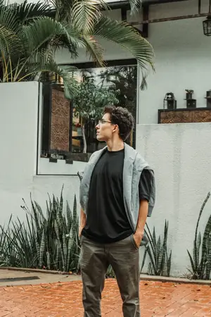 De pie con polera negra UEBOS y camisa abierta