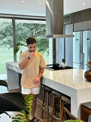 En la cocina con el jardín detrás, polera beige UEBOS