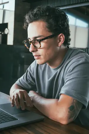 Trabajando en la laptop con polera gris UEBOS
